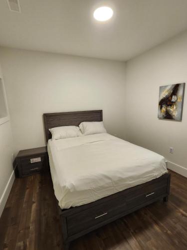 a bedroom with a bed with white sheets and two night stands at Lakeview Breaktrail Stays in Bedford