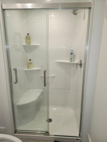 a shower with a glass door in a bathroom at Lakeview Breaktrail Stays in Bedford