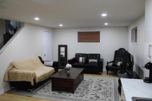 una sala de estar con un sofá y una mesa en Perfect location brand new basement 3 and half appartment, en Laval
