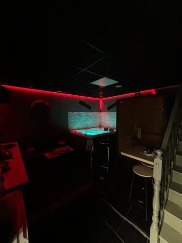 a dark room with a desk and a red light at Ô Saphir Spa - Maison N1 in Denain