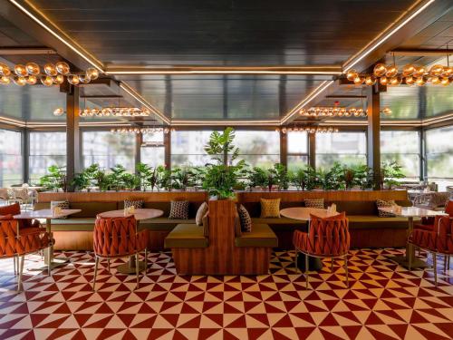 イスタンブールにあるibis Styles Istanbul Kurtkoyのテーブルと椅子と植物のあるレストラン