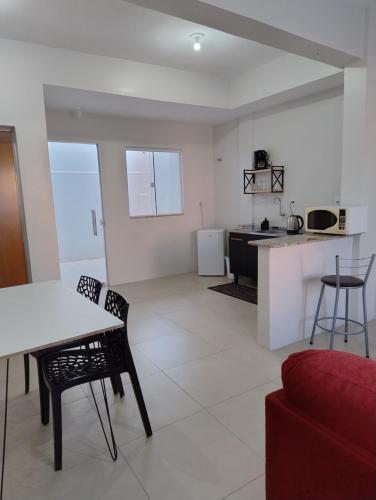 a kitchen and living room with a table and chairs at Apartamentos modernos próximos a tudo in São Gabriel
