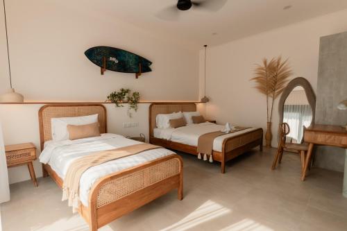 una camera da letto con due letti e uno specchio di Dawn Villa Canggu a Canggu
