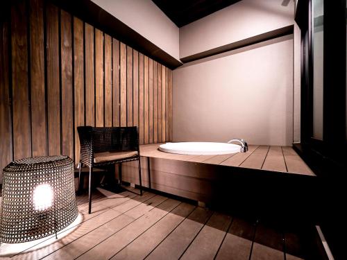 un sauna avec baignoire et chaise dans une pièce dans l'établissement Randor Hotel Namba Osaka Suites, à Osaka