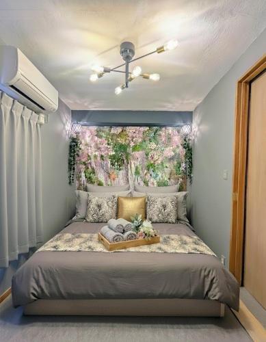 a bedroom with a large bed with a flower painting on the wall at Sakura Fan 2F in Tokyo
