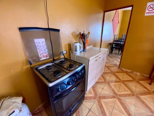 a kitchen with a stove and a counter top at Hostal Nuevo Sol y Viento in San Pedro de Atacama