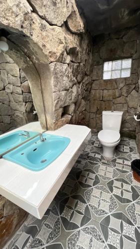 a stone bathroom with a sink and a toilet at Gusti Home Stay Ubud in Ubud