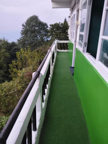 a green and white balcony of a house at 12 Degree in Takdāh