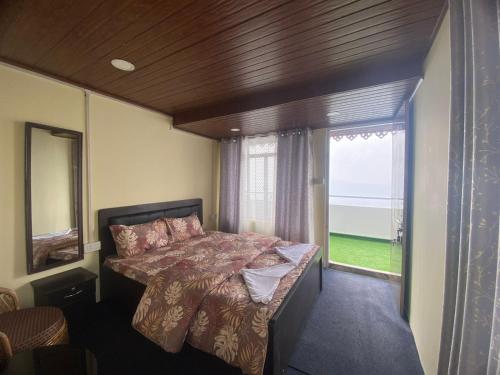 a bedroom with a bed and a large window at 12 Degree in Takdāh