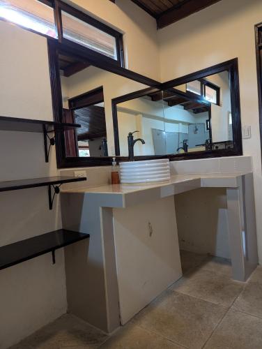a bathroom with a large mirror and a sink at Mountain Lodge CheTica in San Jerónimo