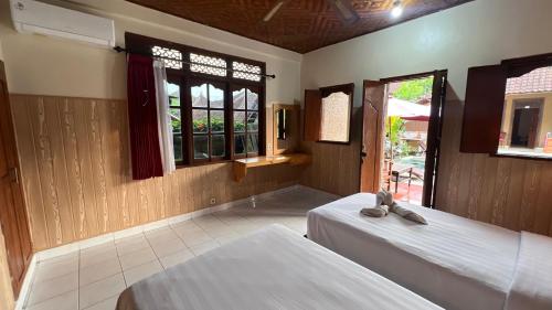 Ένα ή περισσότερα κρεβάτια σε δωμάτιο στο Gusti Home Stay Ubud