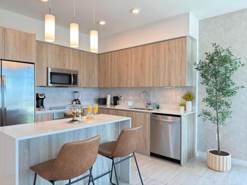 a kitchen with a island with chairs and a plant at Desing district, great apartment in Miami