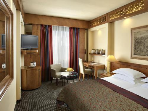a hotel room with a bed and a desk at Dan Panorama Jerusalem Hotel in Jerusalem