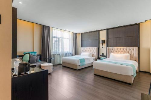 ein Hotelzimmer mit zwei Betten und einer Couch in der Unterkunft Manyueju Hotel 