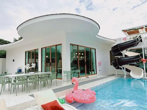 a pool with a pink inflatable swan in a house at PNT LUXURY JOMTIEn in Jomtien Beach