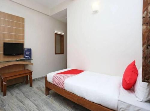 a bedroom with a bed and a desk and a television at Hotel Vijay Palace in Bhopal