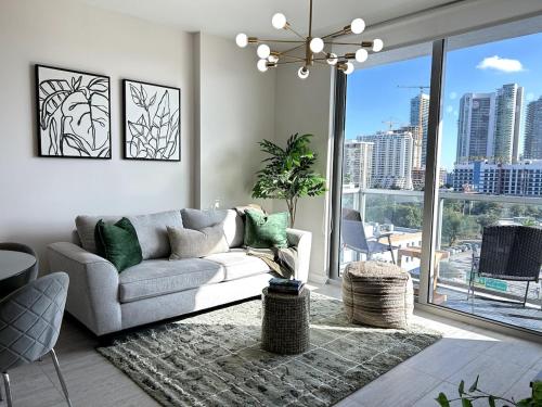 a living room with a couch and a large window at Miami design district, view of the bay - city in Miami