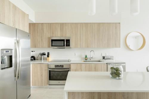 a white kitchen with a refrigerator and a sink at Miami design district, view of the bay - city in Miami