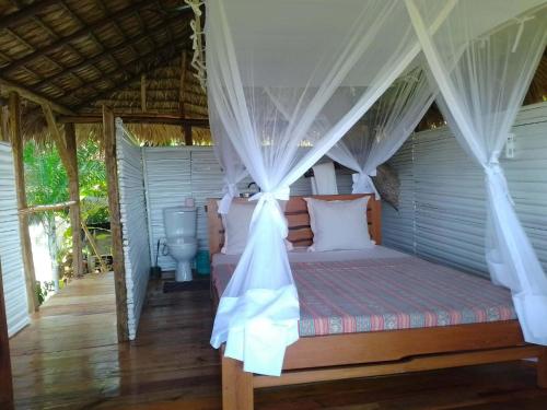 贝岛Corto Novo Maison d'hôtes-Camping的一间卧室，里面有一张带帷幔的床