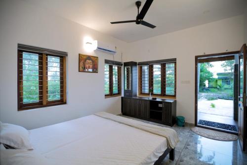 a bedroom with a bed and a ceiling fan at Dolphins Turf in Mararikulam
