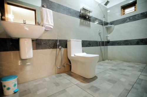 a bathroom with a toilet and a sink at Dolphins Turf in Mararikulam