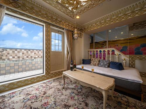 a bedroom with a bed and a table and a window at Hotel PENTHOUSE Kanayama - Adult Only in Nagoya