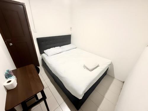 a small bedroom with a white bed and a table at xxzNAP - Khaosan Road สแนป ตรอกข้าวสาร in Bang Bua Thong Railway Station