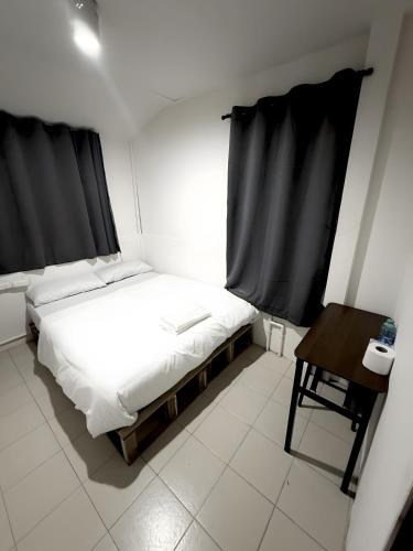 a small bedroom with a bed and a table at xxzNAP - Khaosan Road สแนป ตรอกข้าวสาร in Bang Bua Thong Railway Station