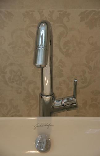 a silver faucet on top of a sink at Les Suites Champenoises in Reims