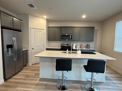 una cocina con una isla grande con 2 taburetes en A modern retreat and Gateway to Yosemite, en Merced