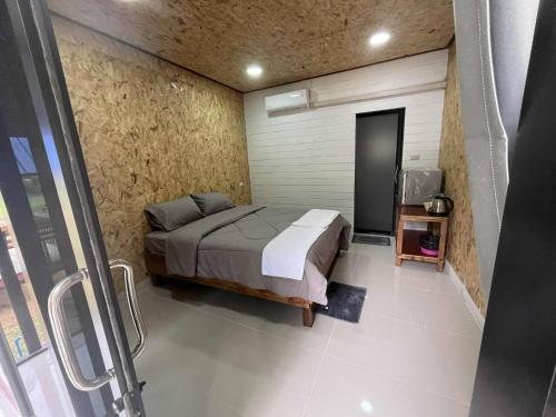 una camera da letto con un letto e una TV di Grand Bungalow a Ban Ting Rai