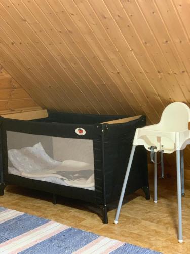 a black bunk bed with a white chair in a room at Authentic Log Cottage with Hot Tub in Ranua