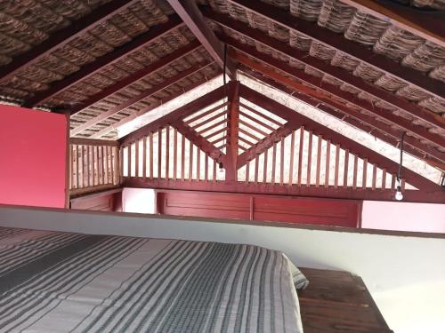 a room with a bed and wooden ceilings at Chalé pé na areia e vista Mar in Ilhéus