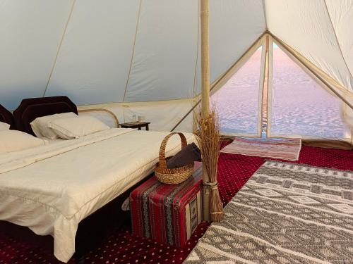 una habitación con una tienda de campaña con una cama y una cesta en ShootingStar Private Camp, en Shāhiq