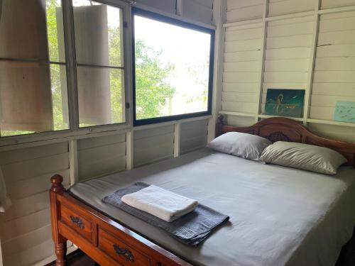a bedroom with a bed with two towels on it at Nazo Boutique Bungalows in Wok Tum