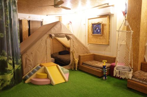 a room with a tent with a bed and a swing at HB01 テントと芝生が広がるお部屋 小田原港3分 8名可 箱根板橋駅徒歩8分 早川駅徒歩7分 Tent and lawn room Odawara Port 3 minutes 8 people Hakone Itabashi Station 8 minutes on foot Hayakawa Station 7 minutes on foot in Odawara