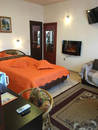 a bedroom with a bed with an orange comforter at Guesthouse Elizabeth in Samokov