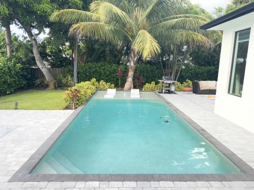a swimming pool in a yard with palm trees at Tropical Oasis in Naples