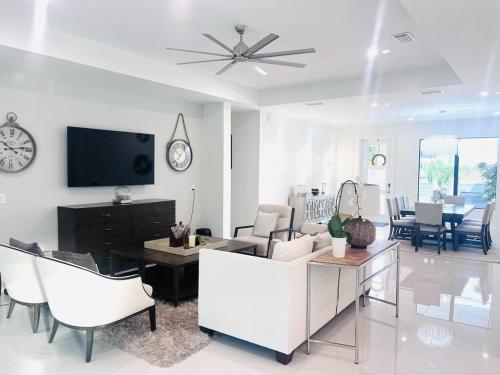 a living room with white furniture and a tv at Tropical Oasis in Naples