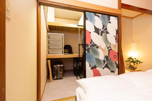 a view of a bedroom with a bed and a mirror at Thresora East Tokorozawa 池袋新宿アクセス良好 隠れ家一軒家 in Tokorozawa
