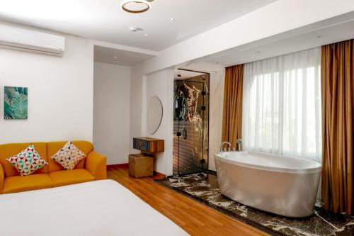 baño con bañera grande y sofá en New LA Veranda Pyramids Inn, en El Cairo