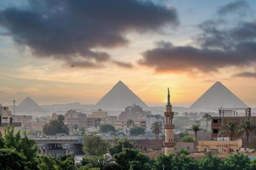 una ciudad con las pirámides en el fondo en New LA Veranda Pyramids Inn, en El Cairo