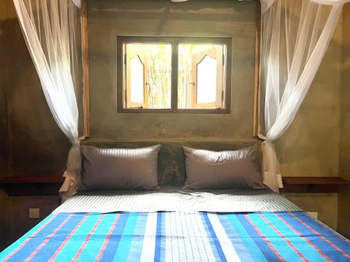een bed in een kamer met een raam bij Into The Blue - Beach House in Unakuruwa