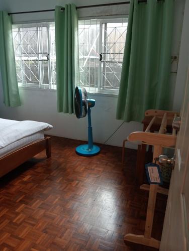 a bedroom with a fan in a room with windows at italay in Krabi