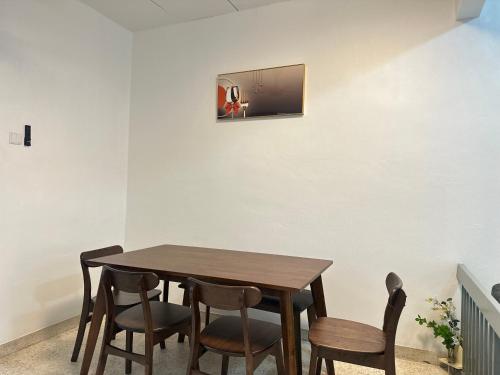 einen Esstisch mit Stühlen und einen TV an der Wand in der Unterkunft 3 Bedrooms Single Storey Terrace at Taman Inderawasih ,12mins to Penang Bridge , 5mins to Sunway Carnival Mall in Butterworth