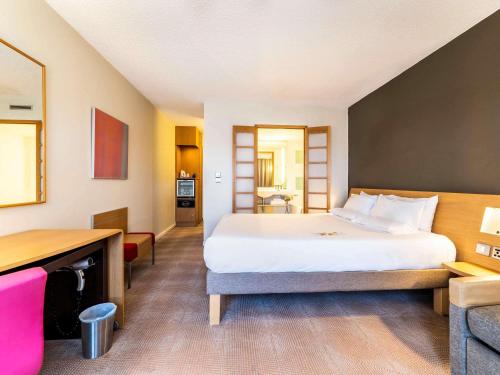 a hotel room with a bed and a desk at Novotel Southampton in Southampton