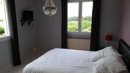 - une chambre avec un lit blanc et 2 fenêtres dans l'établissement Magnifique villa au calme clim parking piscine, à Six-Fours-les-Plages