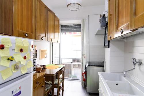 a kitchen with wooden cabinets and a refrigerator at Casa Vacanze Nonna Elena in Rome