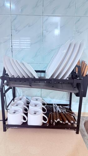 een plank met een heleboel witte mokken bij Kandy city view Residence in Samarakonehena