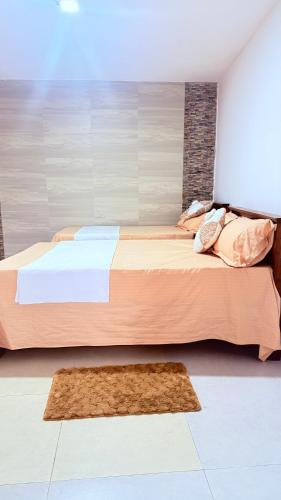 een slaapkamer met 2 bedden en een tapijt bij Kandy city view Residence in Samarakonehena